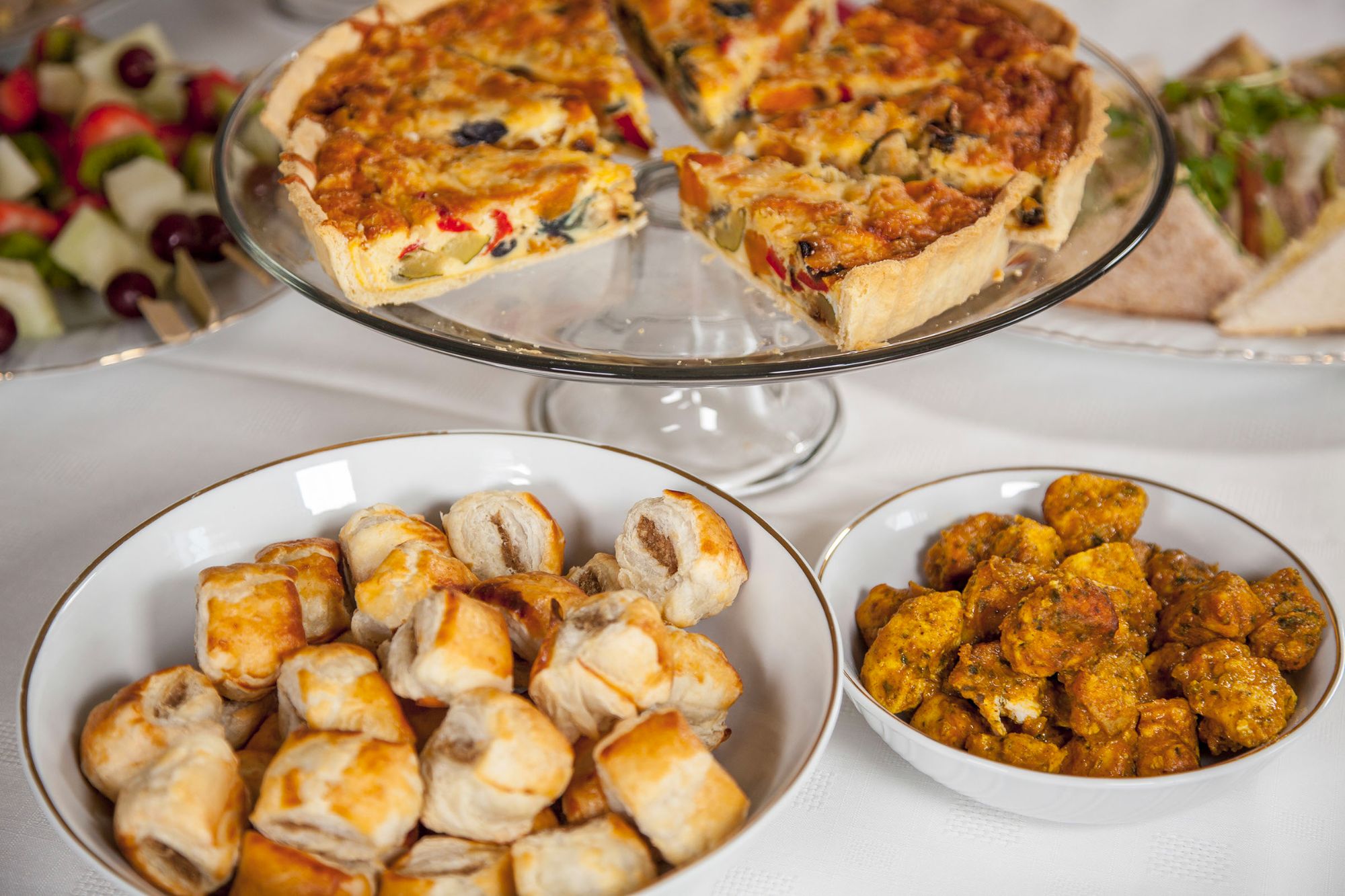 Catering spread with quiche and sausage rolls